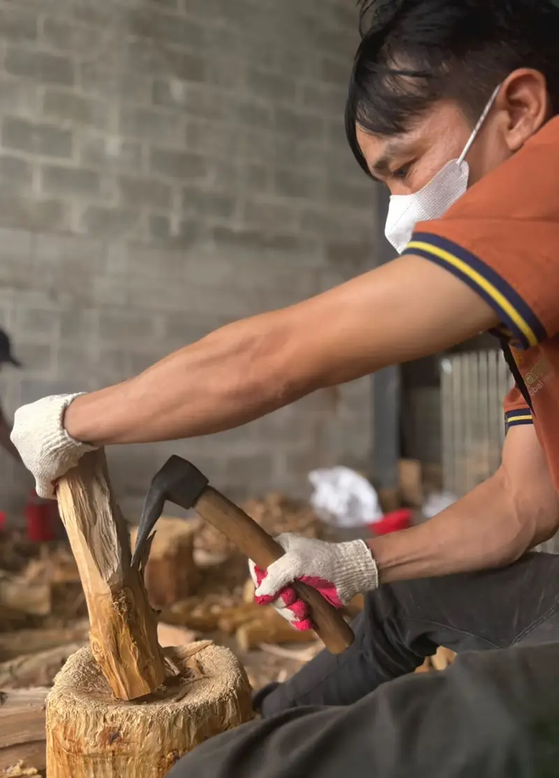 A craftsman splitting sandalwood by hand